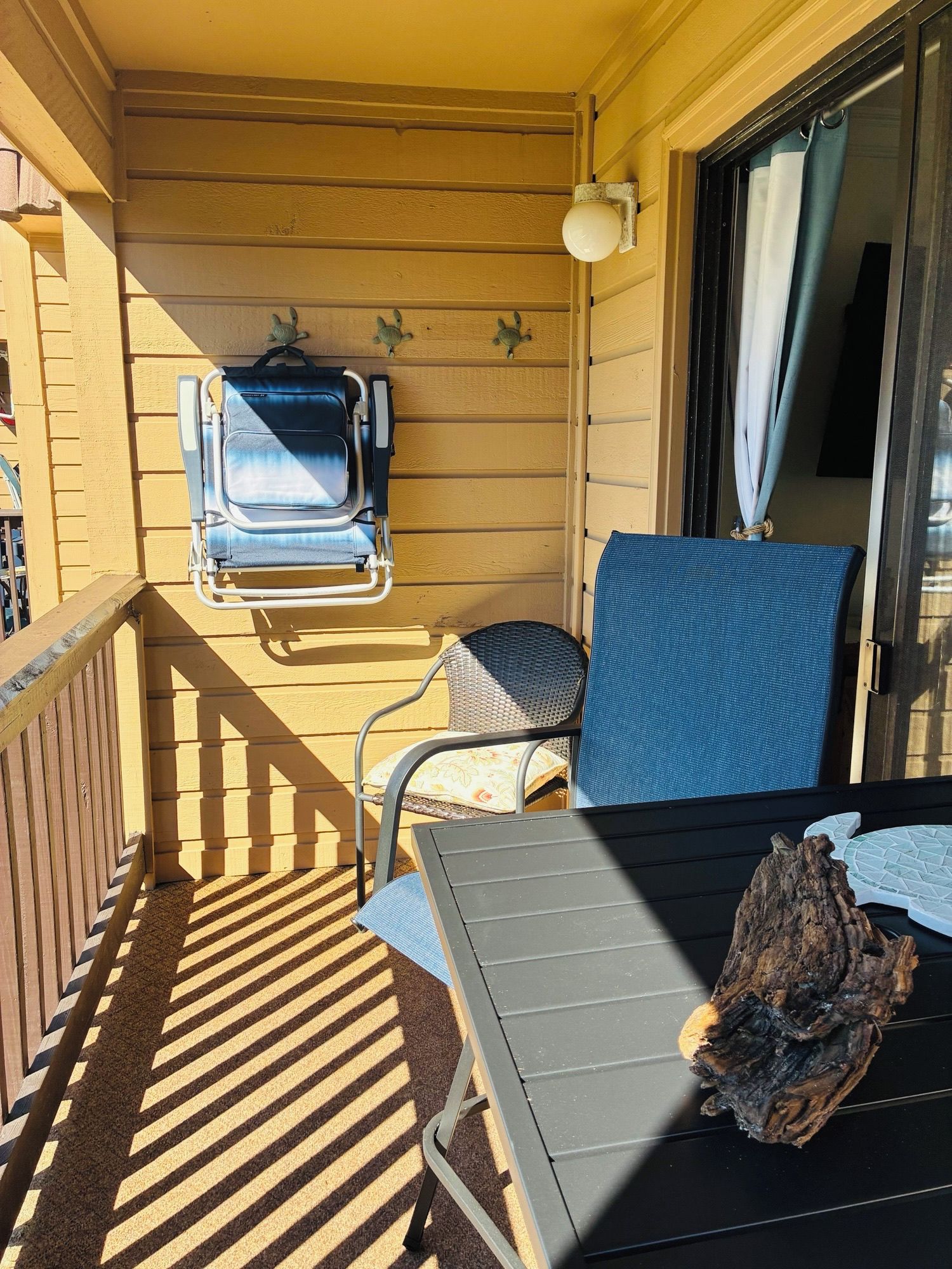 Un balcone con tavolo, due sedie, una lampada e un elemento decorativo.