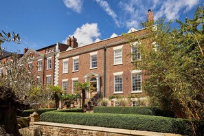 A traditional brick building with a symmetrical facade, a central entrance with a staircase, and well-maintained hedges and plants. - Host & Stay | Topsail (Whitby)