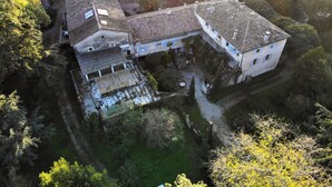 An aerial view of a residential area with multiple buildings, a courtyard, and surrounding greenery. - Country House “Gîte Noisettes” with Shared Pool, Private Terrace, and Wi-Fi (Saint-Didier-sous-Aubenas)