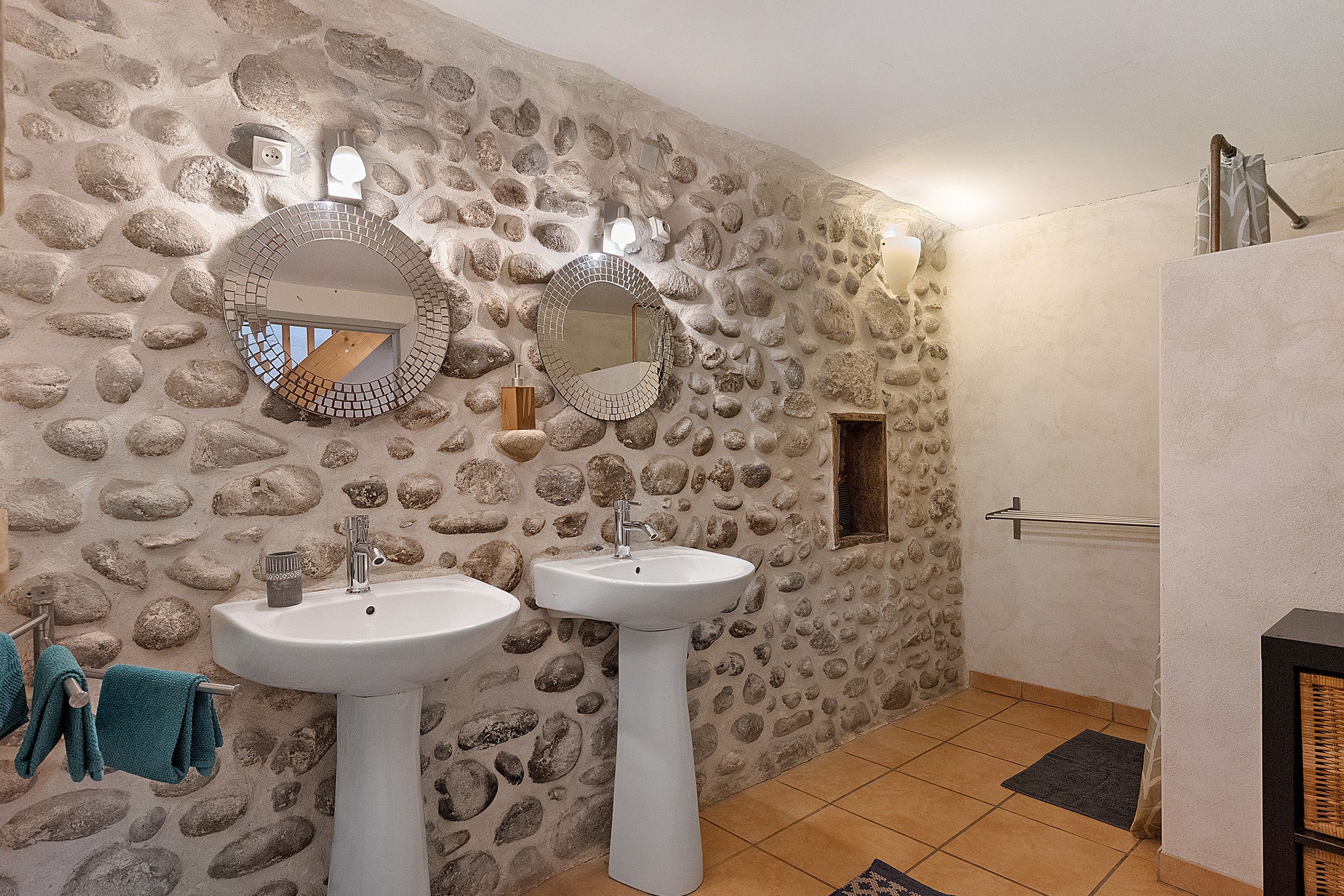 A bathroom with two sinks, a mirror, and a shower area.