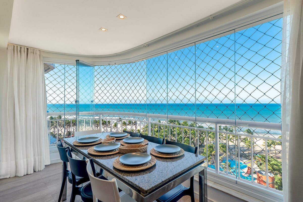 Ein Essbereich mit Tisch für sechs Personen, mit Blick auf Pool und Strand.