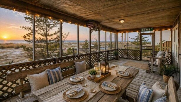 A wooden deck with a table set for two, overlooking a beach at sunset. - Beach front 3 Bedroom home 3 Home (Milton)