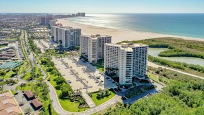 Un hotel de grans alçades amb un pàrquing, una platja i un riu.