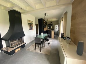 Una cocina moderna con estufa integrada, un comedor con mesa de vidrio y una isla de cocina.