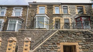 A multi-story stone building with a central staircase, multiple windows, and a small entrance. - 5 Gelli Terrace (Caerphilly)