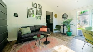 A modern living room with a sofa, coffee table, and a dining area with chairs.