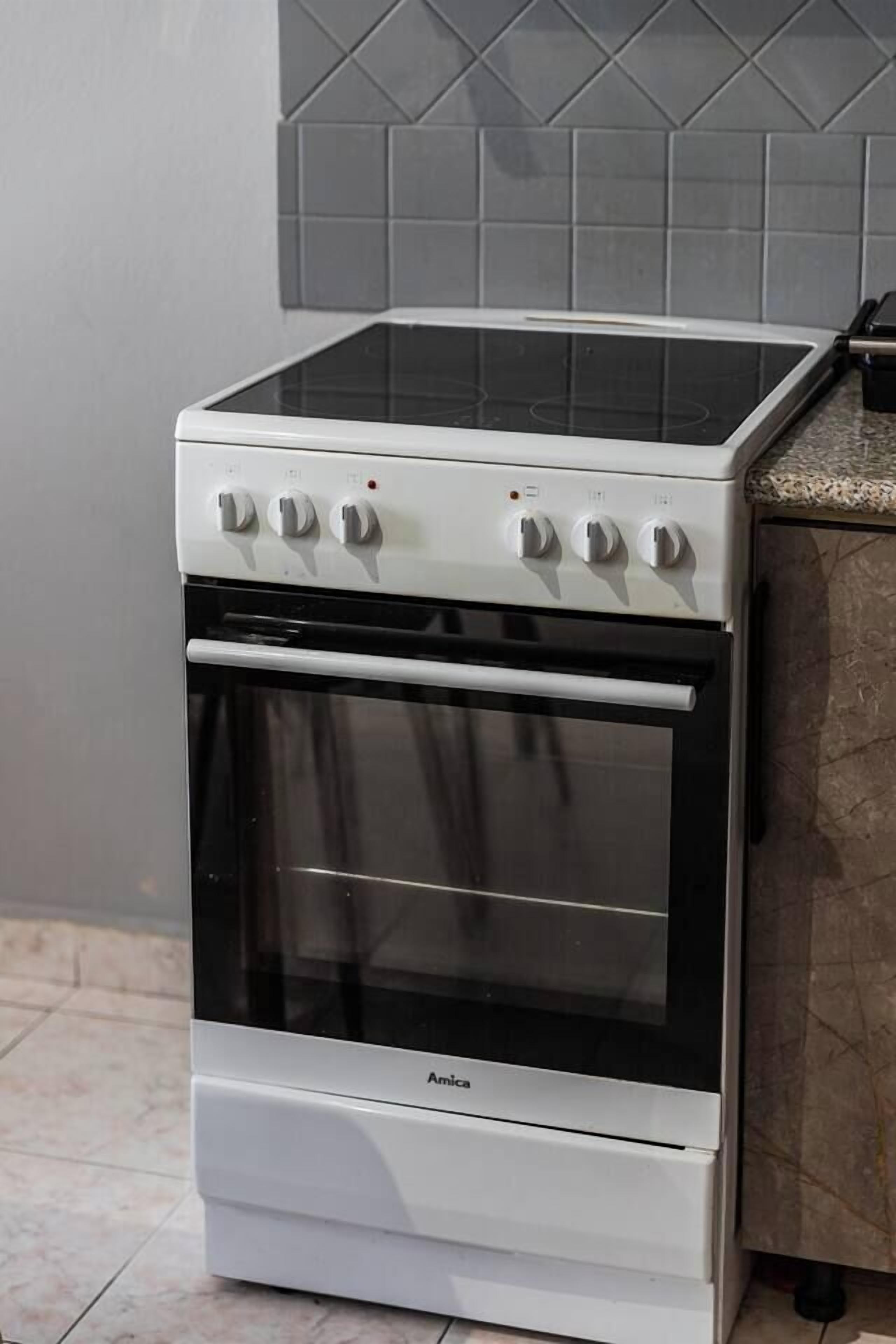 Une cuisinière blanche avec quatre boutons et une seule porte de four.