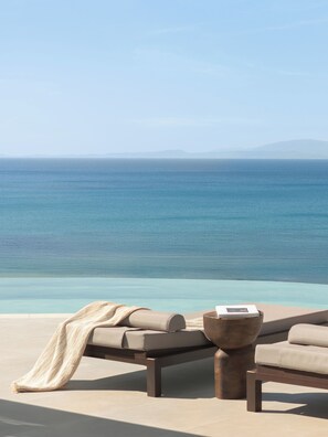 A beachside lounge with a view of the sea and distant mountains. - Sundara, Exclusive Seaview Estate with Grand Pool & Direct Beach Access (Σκάλα)