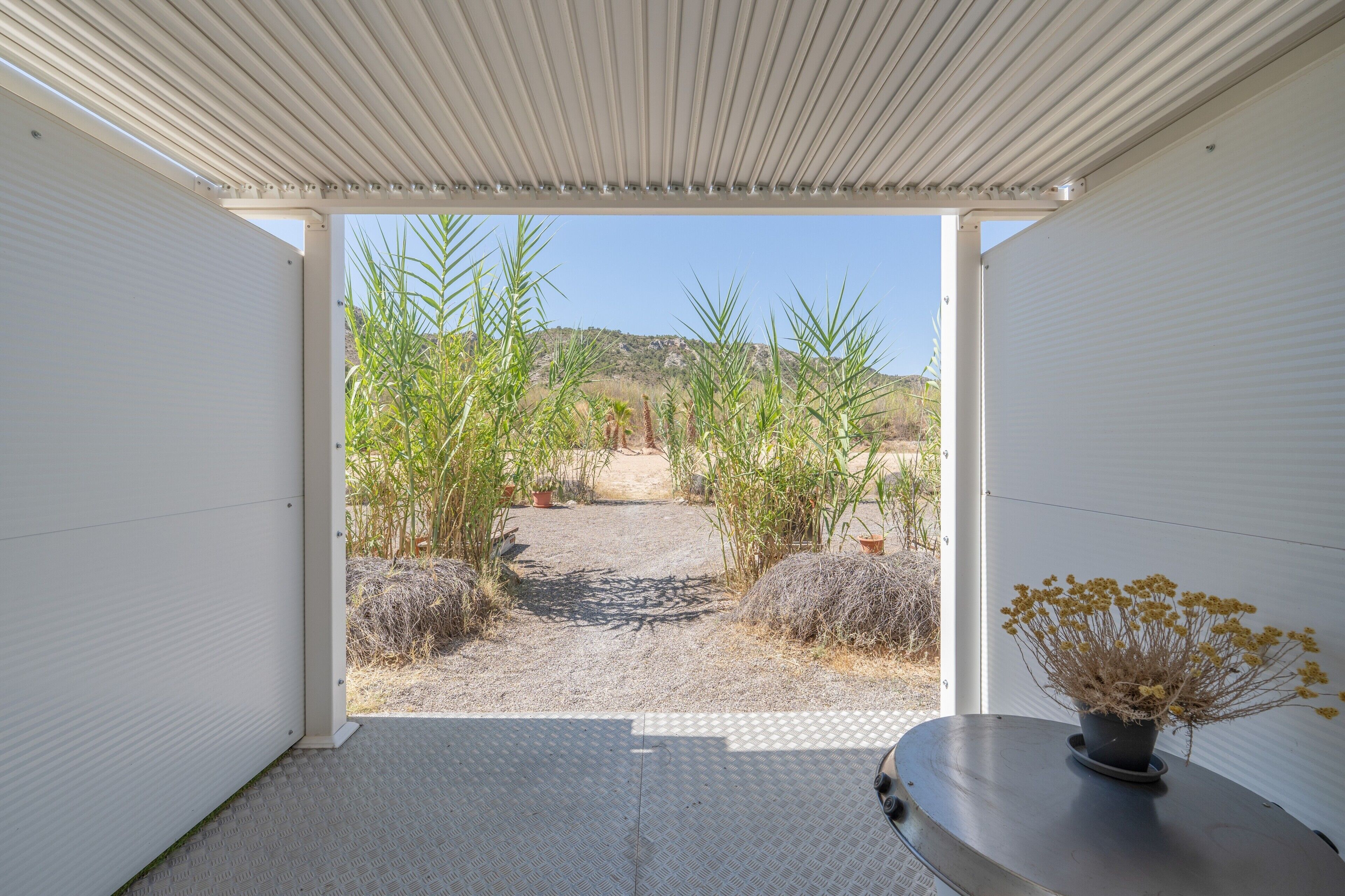 Un espacio interior moderno con vista a un paisaje desértico a través de un ventanal abierto.