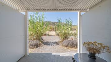 Un espacio interior moderno con vista a un paisaje desértico a través de un ventanal abierto.