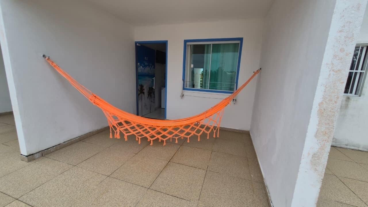 A room with a hammock, a door, and a window.