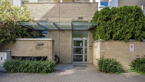 Ingresso di un edificio con porta in vetro, una bicicletta parcheggiata e un cartello che indica divieto di sosta.