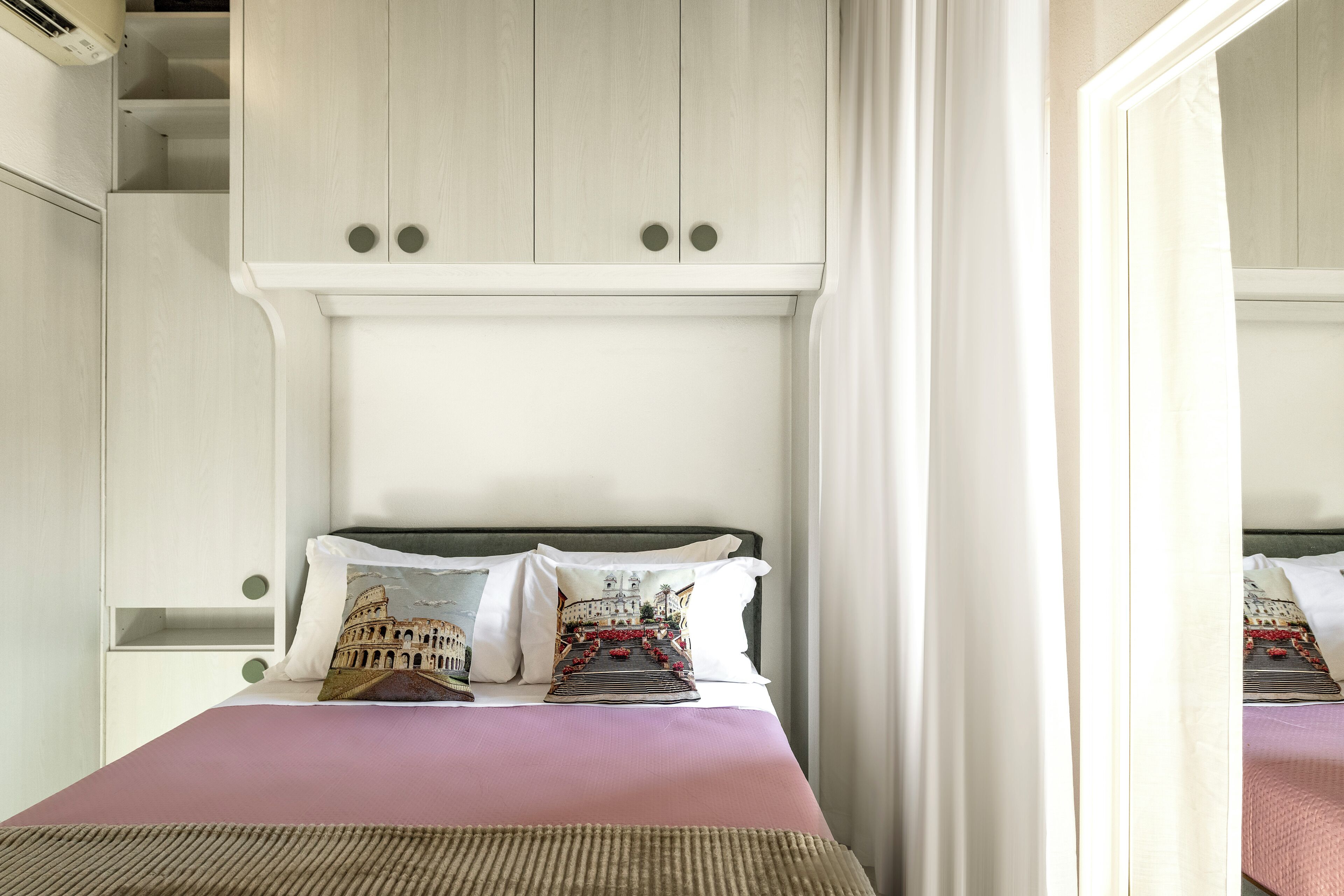 A bed with a headboard, pillows, and a bedspread.