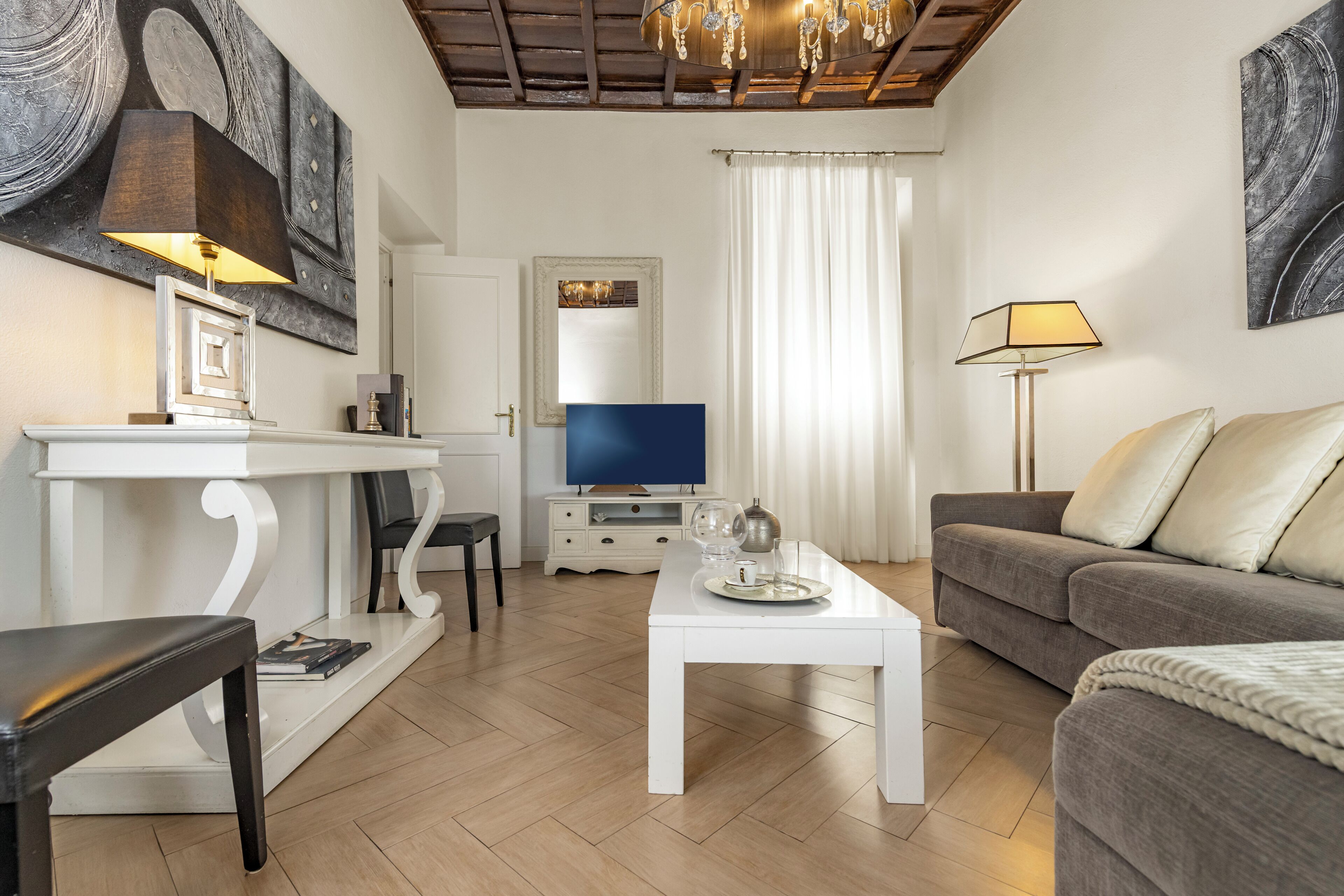 Una sala de estar con televisor, sofá, mesa de centro y un comedor con mesa y sillas.