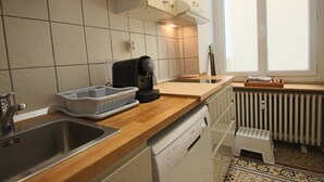 Eine Küche mit Spüle, Kaffeemaschine und Fenster.