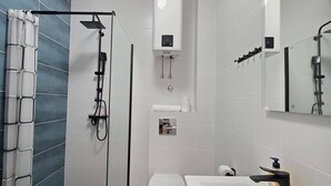 Une salle de bain moderne équipée d’une douche, de toilettes et d’un lavabo.