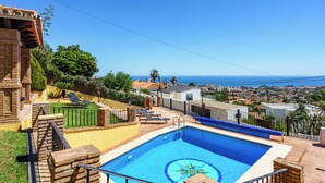 A swimming pool with a decorative edge, a sun lounger, and a view of the ocean. - Spacious 5-bedroom villa with Top views and heated pool in charming Benalmádena (Benalmádena)