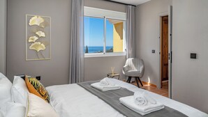 A hotel room with a bed, a chair, a window with a view, and a wall art piece. - Spacious 5-bedroom villa with Top views and heated pool in charming Benalmádena (Benalmádena)