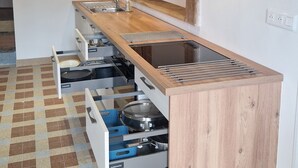 Eine Küche mit Holzschränken, einer integrierten Spüle und einem Fliesenboden mit Muster.