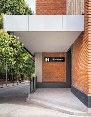 Una entrada de edificio con un letrero que dice 'LIMEHOME' y fachada de ladrillo.