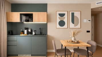 A modern kitchen with a built-in microwave, a sink, and a dining area with a table and chairs.