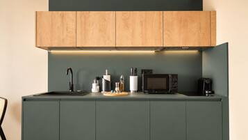 A modern kitchen with a built-in microwave, coffee maker, and a sink.