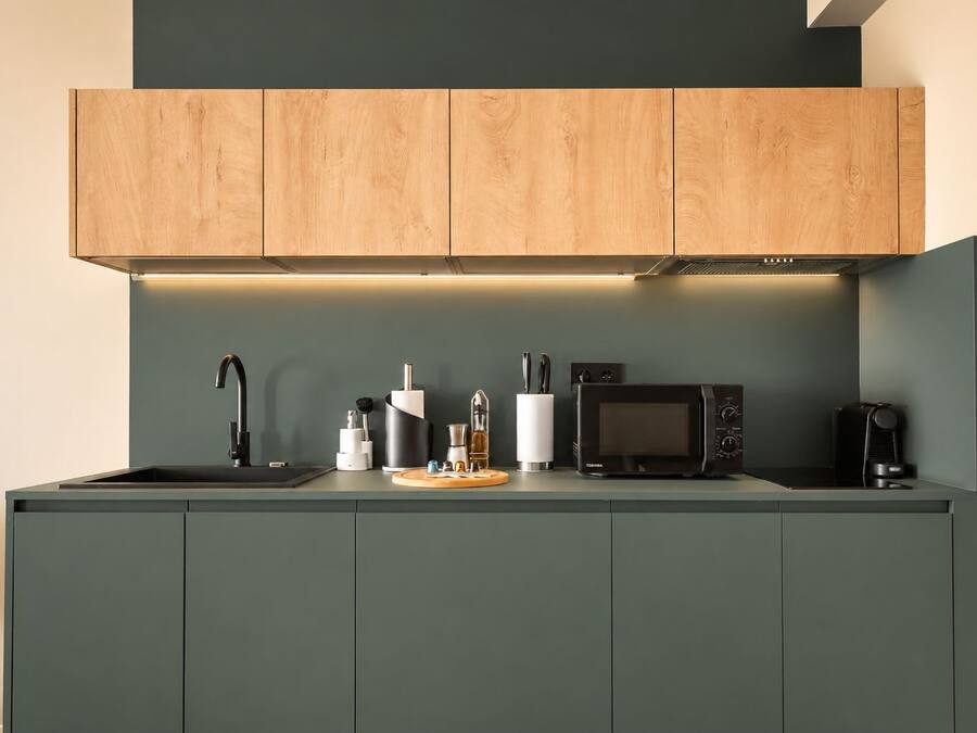 Una cocina moderna con microondas integrado, cafetera y lavaplatos.
