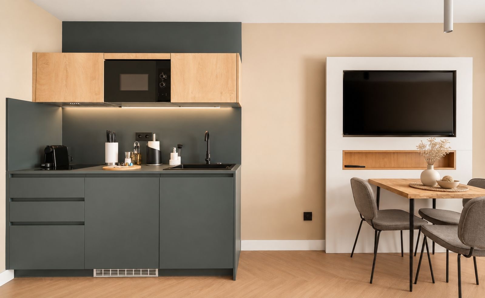 A modern kitchen with dark cabinets, a microwave, and a coffee maker.