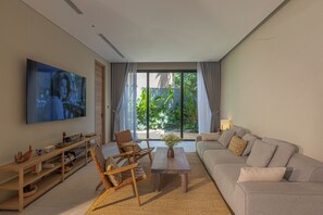 Ein modernes Wohnzimmer mit einem Flachbildfernseher, Holzmöbeln, einer Couch und einem großen Fenster mit Blick auf Grünflächen.