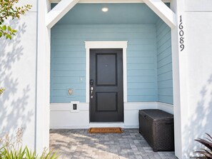 A house entrance with a dark door, a mailbox, and a number 16089 on the wall. - Modern 5 Bedroom Townhome at Windsor Cay 89BL (Clermont)