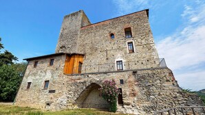 A historic stone building with a wooden door, a balcony, and a flower box. - Medieval Castle between Langhe and Monregalese (Borgo)