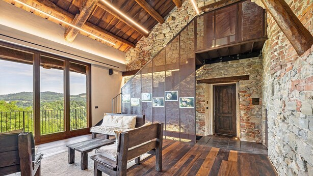 A spacious room with a wooden floor, a bed, a bench, and a large window offering a view of the outdoors. - Medieval Castle between Langhe and Monregalese (Borgo)
