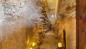 A narrow stone staircase with candles, a wooden door, and a small window. - Medieval Castle between Langhe and Monregalese (Borgo)