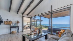 A modern living room with a glass wall, a sofa, a coffee table, and a view of the sea. - Rbk Casa Concón remodel. vista increíble (Concon)