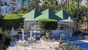 A resort with a pool, outdoor seating, and palm trees. - Sea view * Rooftop Terrace * Pool + Bar *Top Floor (Málaga)