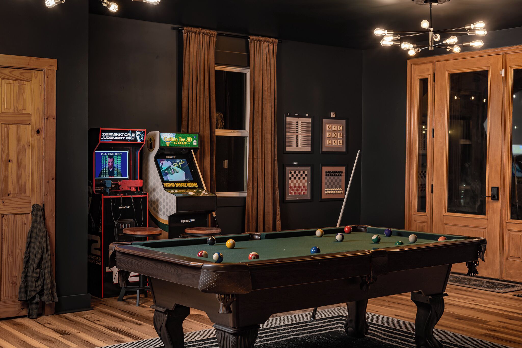 Een pooltafel met een groene viltkleed, omringd door houten wanden en een vloerbedekte vloer.