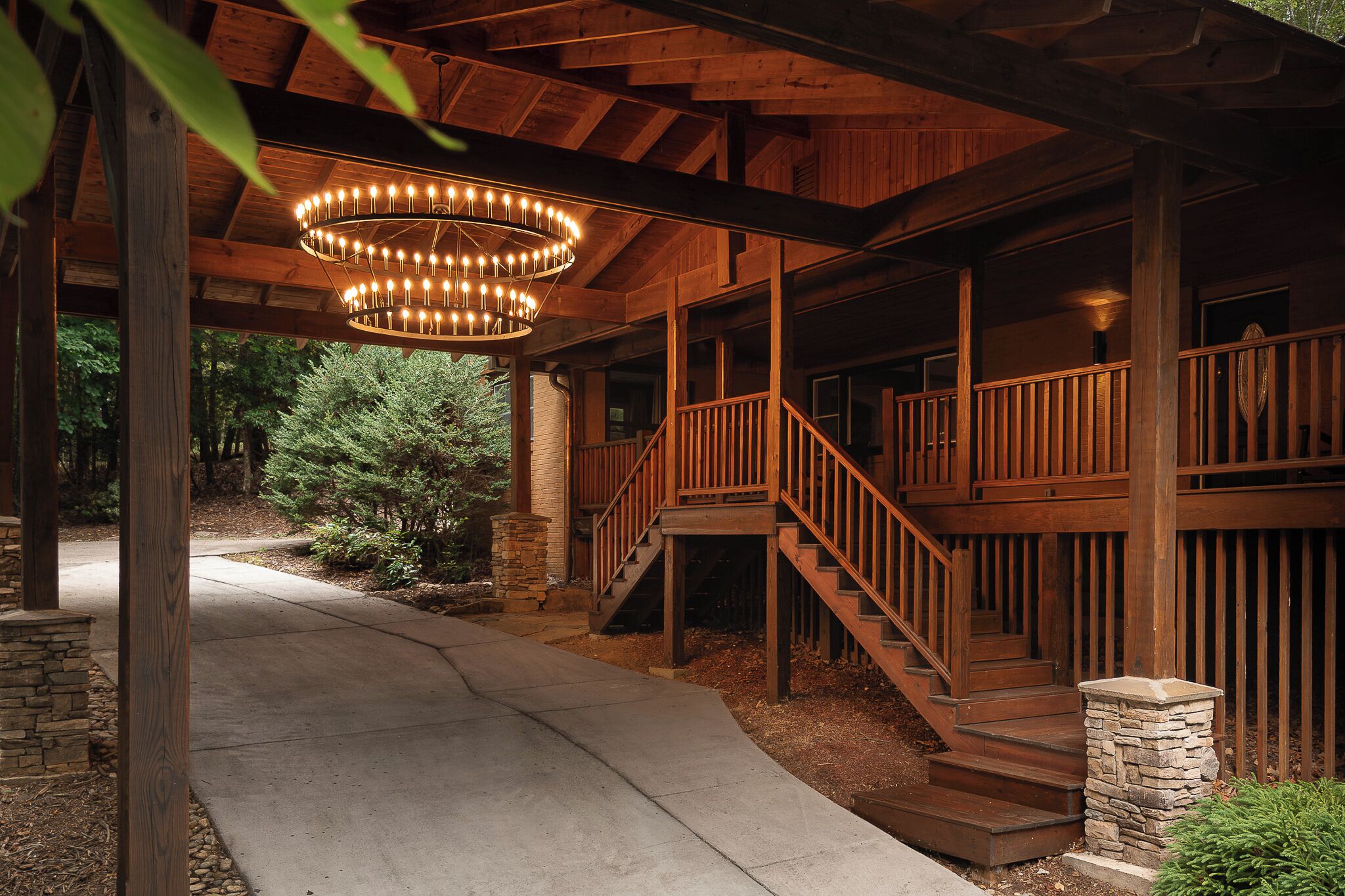 A wooden building with a staircase leading to a balcony, surrounded by trees.