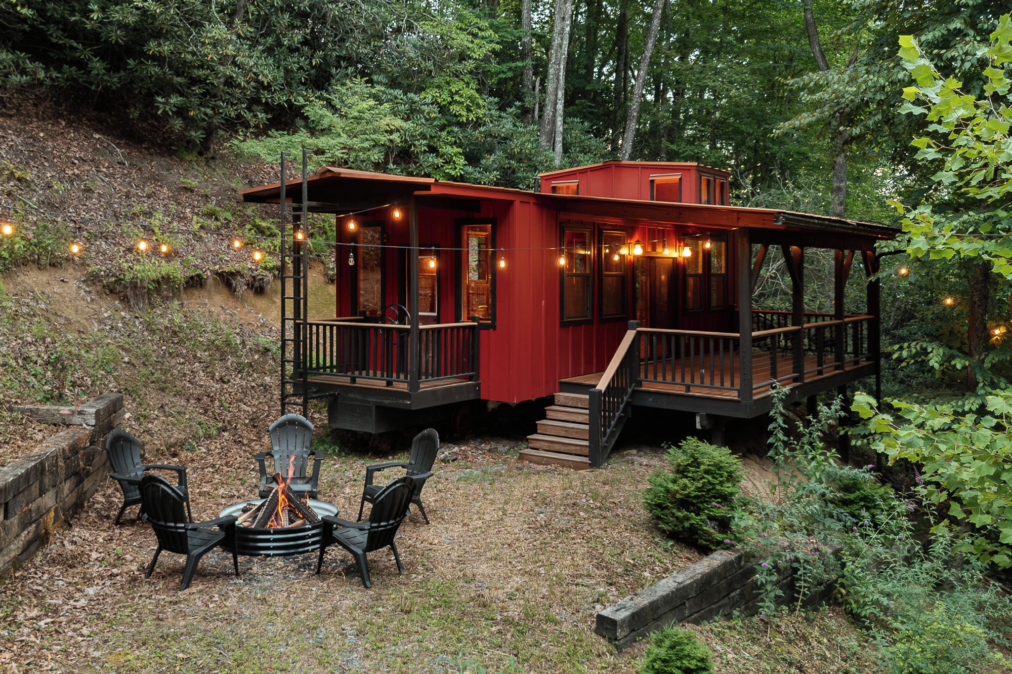 Une cabane avec une terrasse et un espace aménagé pour faire un feu de camp.
