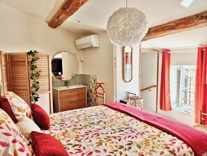 A bedroom with a bed, a dresser, a mirror, a hanging light fixture, and a window with curtains. - Between the vineyards and the canal. Fully renovated 3-story house (Azille)