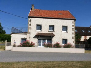 A two-story building with a red-tiled roof, a small balcony on the upper floor, and a front entrance with a door and windows. - 🏡 The Heron's Cozy Little Nest | Sleeps 6–7 | Pets welcome (Felletin)