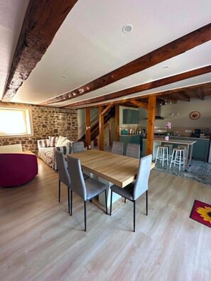 A spacious dining area with a wooden table and chairs, a stone wall, and a staircase leading to an upper level. - 🏡 The Heron's Cozy Little Nest | Sleeps 6–7 | Pets welcome (Felletin)