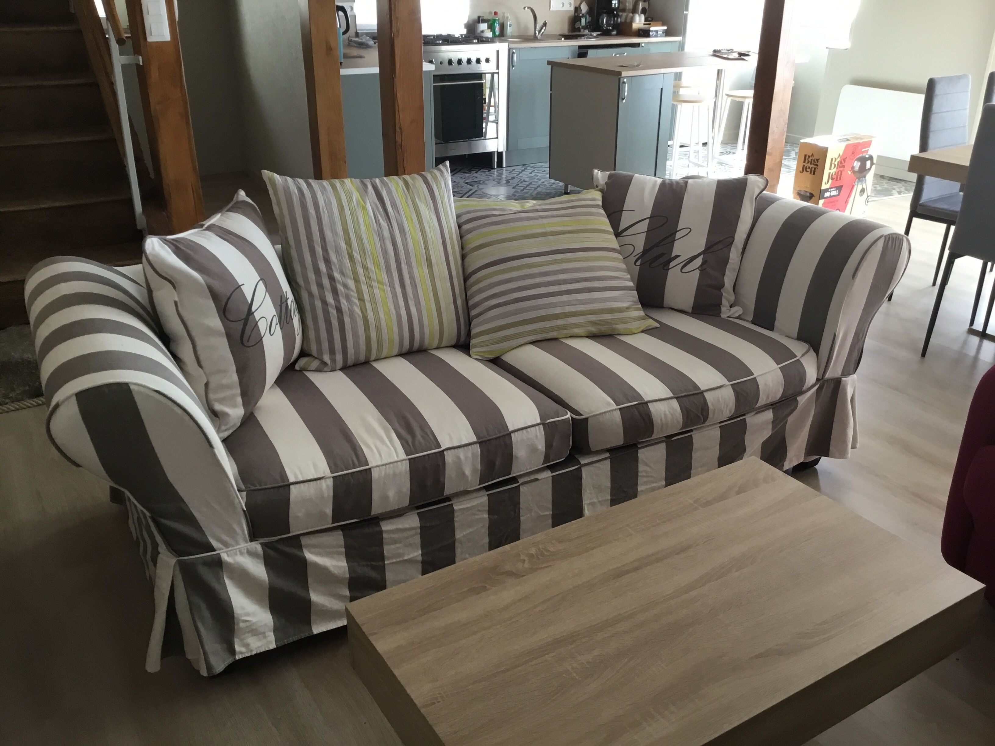 Een gestreepte bank met een houten salontafel in een moderne woonkamer.