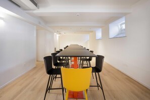 A conference room with a long table, black chairs, and a yellow chair. - B&B Hotel Catania Bellini (Catania)