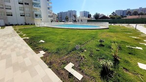 Zona residencial con piscina, sendero pavimentado y abundante vegetación.
