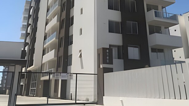 Un immeuble résidentiel à plusieurs étages, doté de balcons, de grandes fenêtres et d’une architecture moderne.
