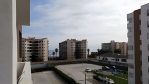 Un quartier résidentiel avec des immeubles à plusieurs étages, une piscine et un ciel dégagé.
