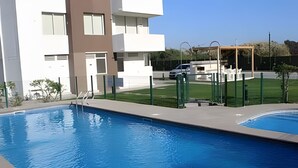 A swimming pool with a clear view of a modern building in the background.