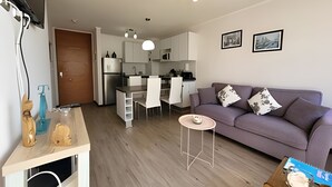 A modern apartment with a kitchen, dining area, and living room.