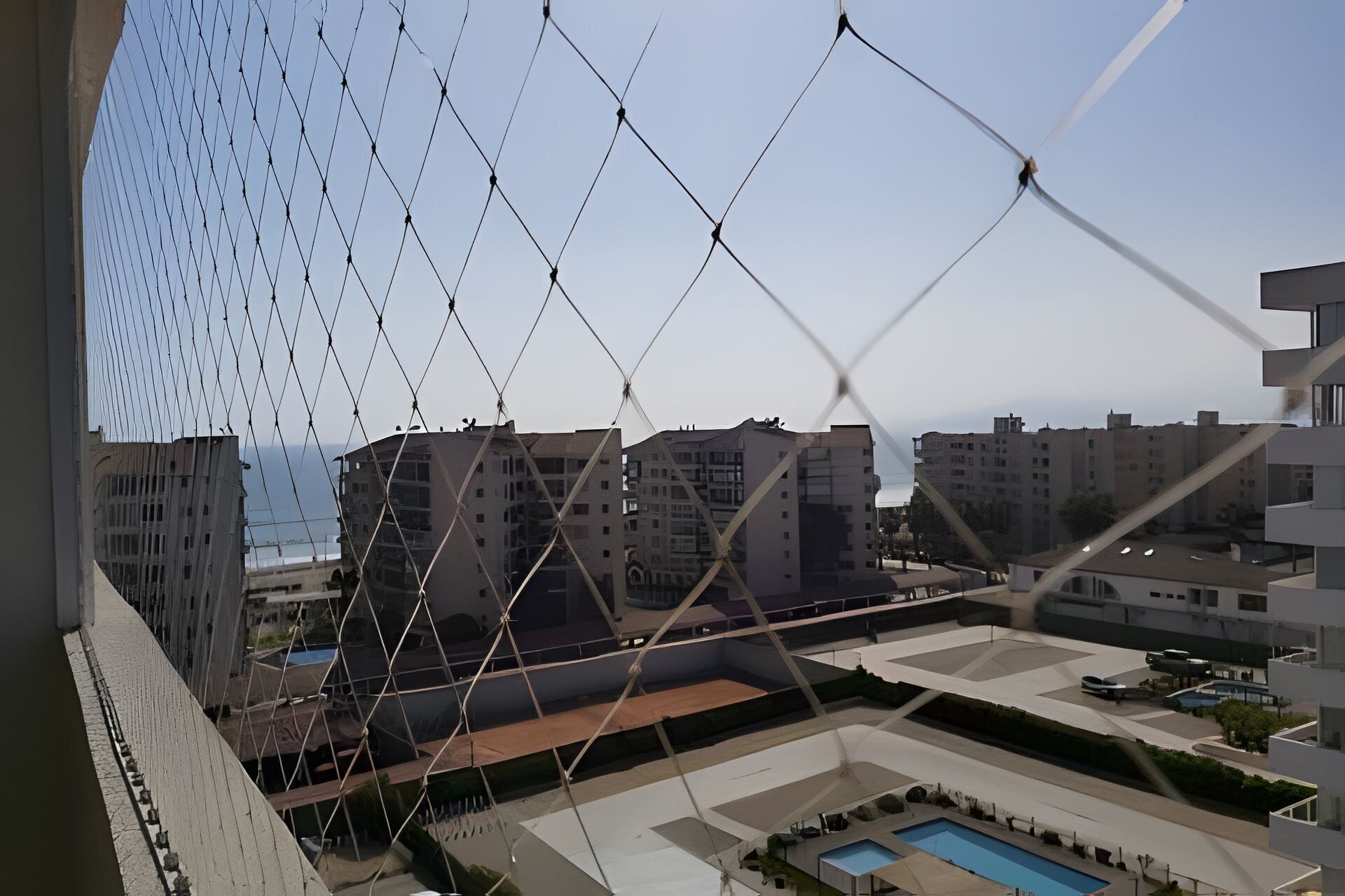 A residential area with multiple apartment buildings, a swimming pool, and a clear sky.