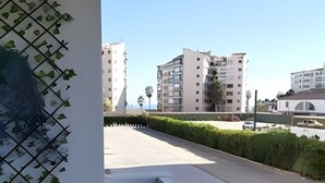 Un balcon donnant sur un paysage urbain, avec des bâtiments et une route.